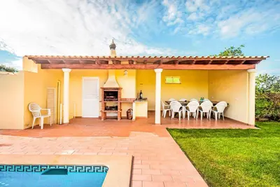 a house with a patio with a table and chairs at Villa Portela in Loulé
