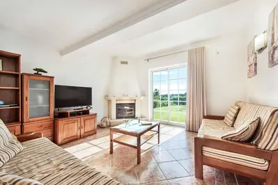 a living room with a couch and a tv at Villa Portela in Loulé
