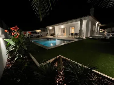 a house with a swimming pool at night at Casa Alegria in Tunes