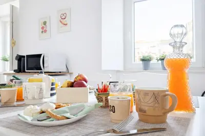 a kitchen table with a plate of food and coffee cups at Varanda da Baixa, cosy apartment, top location, private terrace, barbecue, AC and Wi-Fi in Faro