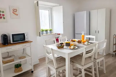 a kitchen with a white table with food on it at Varanda da Baixa, cosy apartment, top location, private terrace, barbecue, AC and Wi-Fi in Faro