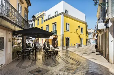 a bedroom with a large bed with blue pillows at Faro Downtown in Faro