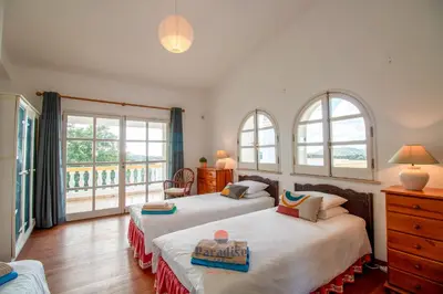 two beds in a room with two windows at 7 Bedrooms, Main House, Bungalow, Private Pool in Fonte da Murta