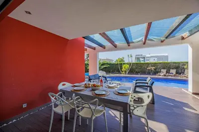 a dining room with a table and chairs and a pool at Villa Gale by Vintage Travel in Galé
