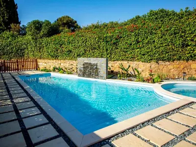 a swimming pool in front of a stone wall at Holiday Home Lotus Villa 2- Albufeira by Interhome in Albufeira