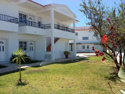 a large white house with a green yard at Apartment mit Terrasse by Interhome in Albufeira