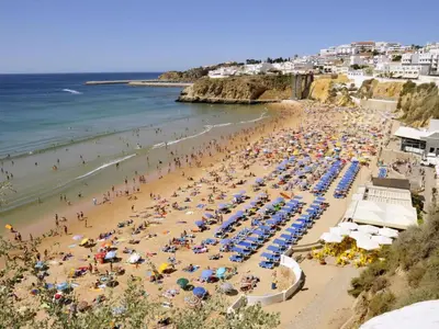 a beach with a lot of people and the ocean at Apartment mit Terrasse by Interhome in Albufeira
