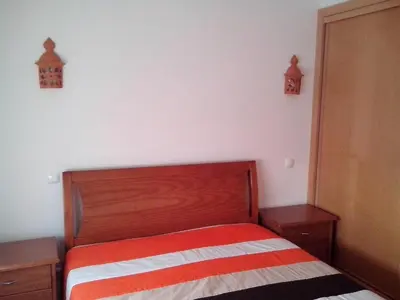 a bedroom with a bed with a red and white striped blanket at Apartment mit Balkon by Interhome in Albufeira