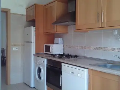 a kitchen with a stove and a sink and a microwave at Apartment Wohnung mit Terrasse by Interhome in Albufeira