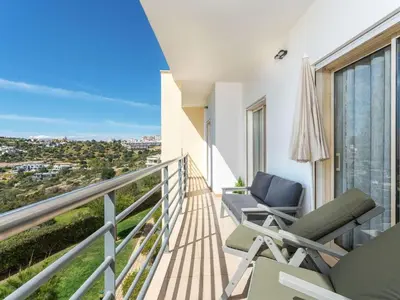 a balcony with chairs and a view of the city at Apartment Elena 2 mit Blick auf das Wasser by Interhome in Albufeira