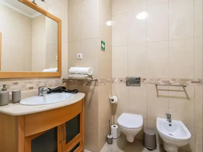 a bathroom with a sink and a toilet and a mirror at Apartment Elena 1 mit Blick auf das Wasser by Interhome in Albufeira