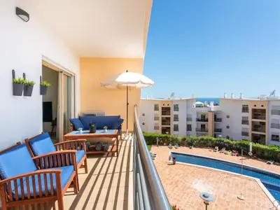 a balcony with a pool and chairs and an umbrella at Apartment Elena 1 mit Blick auf das Wasser by Interhome in Albufeira