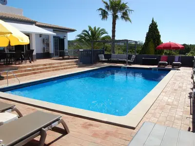 a swimming pool with blue water in a yard at Holiday Home Villa Monte Alegrete by Interhome in Loulé