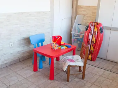 a red table with two chairs and a table with toys on it at Holiday Home Berghütte Villa Romao by Interhome in Barranco de Apra