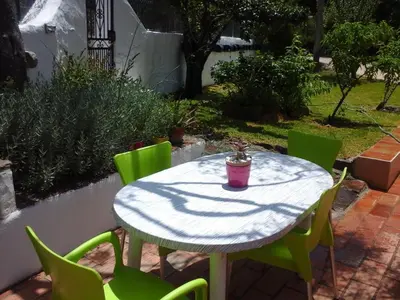 a table with green chairs and a pink cup on it at Holiday Home Berghütte Villa Romao by Interhome in Barranco de Apra