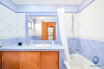 a bathroom with a tub and a sink and a mirror at Vitoria 1 by MTPhomes in Albufeira