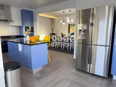 a kitchen with blue cabinets and a stainless steel refrigerator at Villa Nova En-suite luxury, private pool, sea view in Albufeira