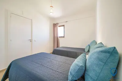 a bedroom with a bed with blue pillows at Bordalo by MTPhomes in Albufeira