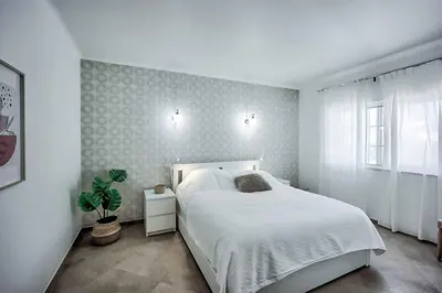 a bedroom with a white bed and a window at Zen Balaia in Olhos de Água