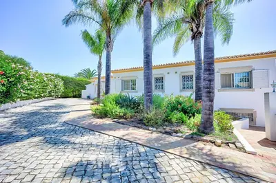 a hammock on a house with a swimming pool at Zen Balaia in Olhos de Água