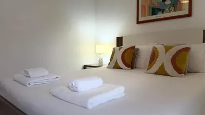 a bed with a blanket and pillows on it at Maple Apartment in Albufeira