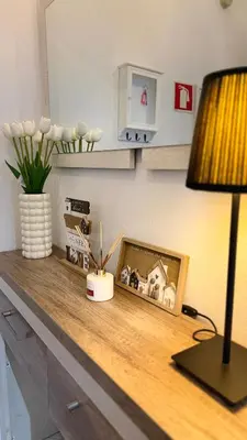 a lamp on a dresser with a painting of a horse at Maple Apartment in Albufeira