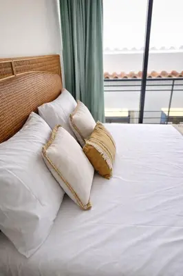 a bed with two pillows on it with a window at Elegant City Center Loft in Faro