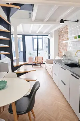 a kitchen and living room with tables and chairs at Elegant City Center Loft in Faro