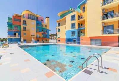 a swimming pool in front of two apartment buildings at Marina Sunny Heaven TatiHomes 2 in Albufeira
