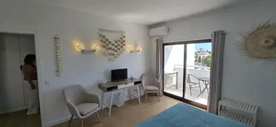 a large swimming pool with chairs and a building at Luxury Sea View Apartment in Albufeira
