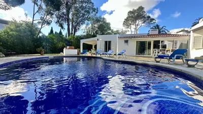 a swimming pool with blue chairs and a house at Villa Morocco with Heated Private Pool for 12 Guests in Albufeira in Albufeira