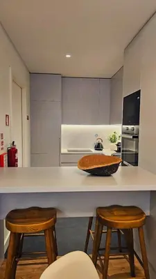 a kitchen with a counter with two stools at Sweet Horizon in Quarteira