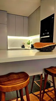 a kitchen with a counter with two stools and a microwave at Sweet Horizon in Quarteira