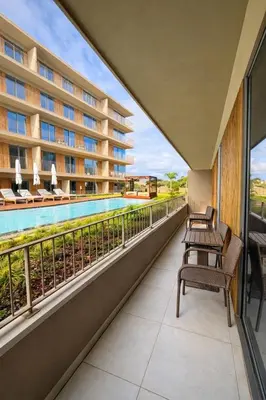 a balcony with chairs and a swimming pool at Horizon Sand Beachfront apartment - Pool View, Quarteira in Bicas