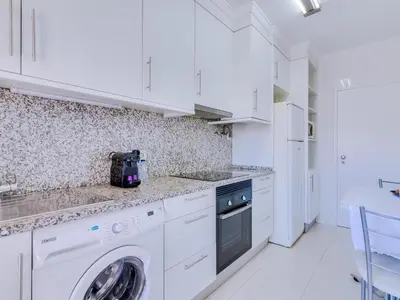 a white kitchen with a washer and dryer at AL - Apartamento Wave 7 in Quarteira