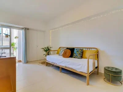 a living room with a bed and a window at AL - Apartamento Wave 7 in Quarteira