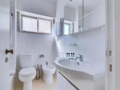 a white bathroom with a toilet and a sink at AL - Apartamento Wave 7 in Quarteira