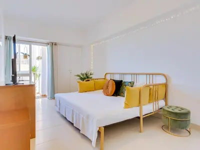 a bedroom with a bed with yellow pillows at AL - Apartamento Wave 7 in Quarteira