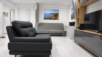a living room with a black chair and a couch at Linda Vista in Albufeira