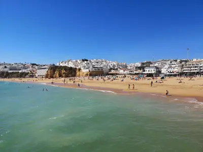 a beach with a bunch of people in the water at Linda Vista in Albufeira