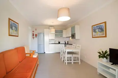 a living room and kitchen with a couch and a table at Apartment Jardins da Falesia in Roja- Pé