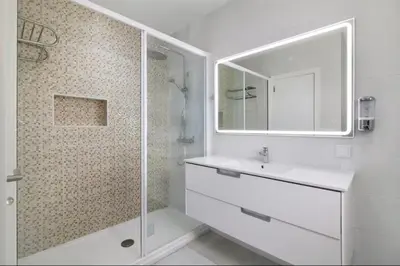 a white bathroom with a sink and a shower at Apartment Jardins da Falesia in Roja- Pé