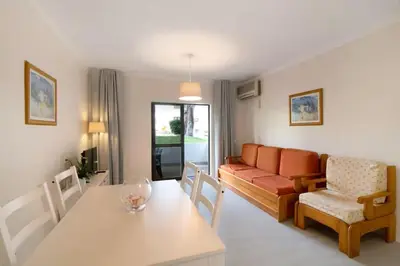 a living room with a couch and a table at Apartment Jardins da Falesia in Roja- Pé