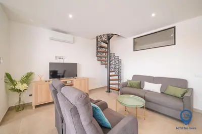 a living room with a couch and a tv at Palmeiras by MTPhomes in Albufeira