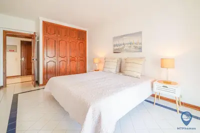 a white bedroom with a large bed with two lamps at Salgados by MTPhomes in Guia