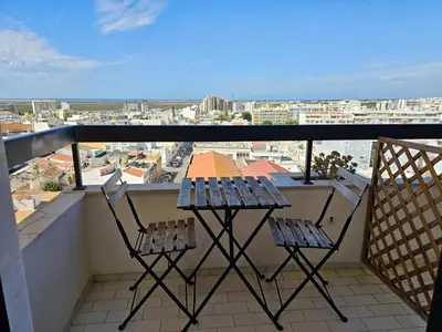 two chairs on a balcony with a view of a city at Blife Chelsya private apartment in Faro