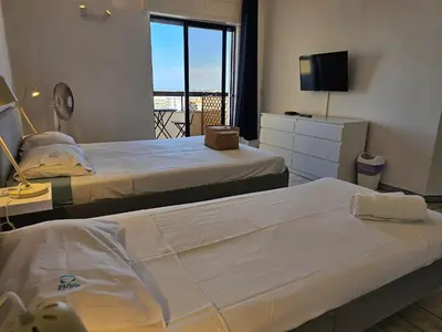 a hotel room with two beds and a television at Blife Chelsya private apartment in Faro