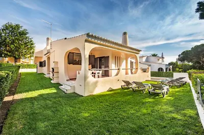 a backyard of a house with chairs and a lawn at Pinhal View in Vilamoura