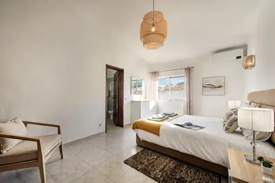 a bedroom with a bed and a table and a chair at Pinhal View in Vilamoura