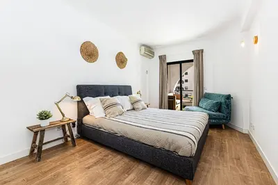 a bedroom with a bed and a blue chair at Luxury Apartment Salgados Village in Guia